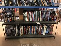 Three-shelf metal unit filled with assorted DVDs including boxsets and standard cases