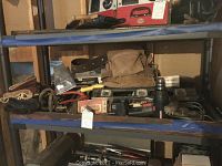 Shelf with assorted tools, tool belt, and boxes including cordless screwdriver, Craftsman drill, halogen spotlight, and gloves