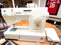 Front-right angled view of Singer Imperial Anniversary Edition electronic sewing machine showing controls and needle area