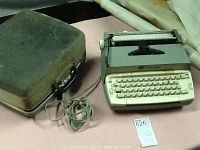 Photo showing the full vintage Smith-Corona electric typewriter next to original carrying case and power cord.