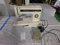 Full side view of the Kenmore electric sewing machine with foot pedal and power cord, showing overall condition and setup.