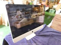 Front right angled view of monitor on blue cloth with warehouse background