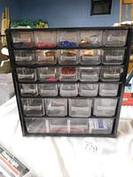 Front view of the small metal workshop storage container showing multiple small clear plastic drawers with various small parts inside.