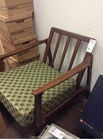 Front view of teak lounge chair showing slatted back and seat cushion