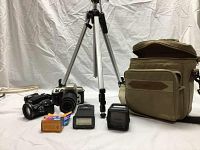 Full view of the lot showing two cameras, tripod, camera bag, flash, film rolls and other accessories