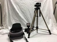 Full lot overview showing tripod, camera bag, camera with lens and flash attached