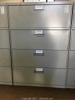 Front view of the gray 4-drawer metal file cabinet with filing category labels on drawers.