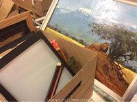 Image showing the signed painting by C. Kiswanta with a lion in landscape, course of snowy mountains, and some frames nearby.