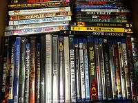 Shelf containing multiple DVD and Blu-ray cases with visible titles including various movie genres and collections.