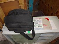 Black soft carrying case, and user manuals arranged on a table.