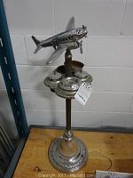 Front view of chrome DC-3 airplane atop ashtray lamp base
