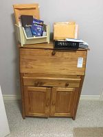 Full view of the Navarra wooden secretary desk with mail sorter and black tray on top containing envelopes and small office supplies.