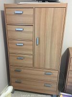 Front view of the highboy chest showing six drawers and one door, wood tone finish with silver handles.