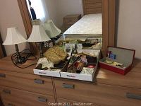 Overview of dresser top showing various jewelry boxes, fans, shawl, photo box, and card holder.