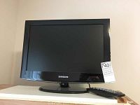 Front view of Samsung TV with remote control placed beside it.