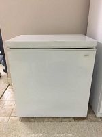 Front view of white Kenmore chest freezer with top lid closed.