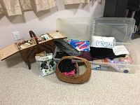 Photo of entire sewing lot showing wooden sewing box, woven basket with fabric, and clear plastic tote containing folded fabric and materials.