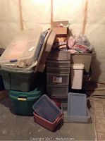Full view of stacked plastic storage totes and drawers in an unfinished room corner.