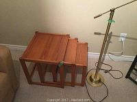 Set of 3 wooden nesting tables stacked nested together, showing their rectangular tops and wood grain finish.