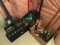 Various yard maintenance tools including shovels and garden tools seen against insulated wall