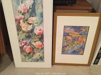 Two framed pictures side by side; floral painting on the left and aquatic themed print on the right.