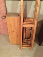 Two wooden shelving units in stacked position, showing solid pine material and slatted shelf design.