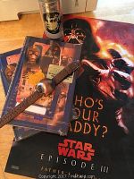 Star Wars Episode III posters, DVDs in packaging, wristwatch, and character cup displayed on a wooden surface.