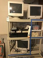 Two Sony Multiscan 100ES monitors and one Dell CRT monitor on shelves with stereo receiver, digital converter and other electronic items below, plus two plastic Keter storage units.