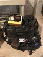 Lot of vintage cameras and accessories displayed on the floor with bag