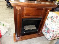 Front view of wood fireplace mantel with black firebox and single wood log insert