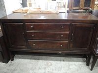 Front view of the dark wood Thomasville dresser showing its three drawers and two cabinet doors.