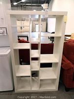 Front view of white modular bookshelf showing staggered open shelf design and dimensions.