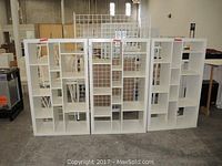 Photo of 3 matching white shelf units side-by-side showing front compartments