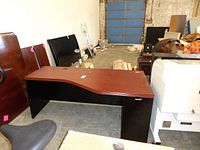 Photo of executive modular desk from angled front-left showing top, black side panels and wave design edge.