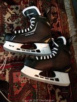 Bauer Supreme ice skates size 10.5 US with Lightspeed Pro blade holder shown on patterned carpet.