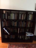 Front view of IKEA cube storage unit filled with books and items