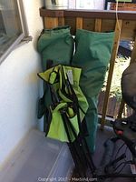 Three green camping chairs folded with two carrying bags visible, showing general lot contents.