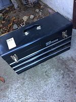 Closed black Sears Craftsman metal toolbox showing brand name and latches.