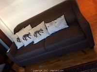 Full view of brown fabric couch with four cushions on seat, showing overall condition and style.