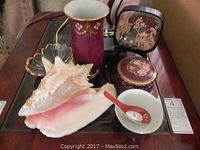 Full view of the six items showing the mixing of ceramics and Asian decor including seashell, vase, dishes, box, and shadow box