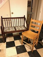 Double seat bench with floral seat and wooden chair on checkerboard floor