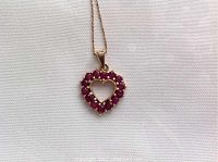 Pendant and chain on white background showing heart shape and ruby settings