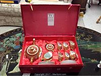 Full Chinese tea set displayed in an open red decorative box, showing the teapot, six tea cups, saucers, sugar bowl and creamer