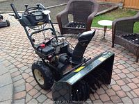 Full view of snowblower showing auger housing, engine, chute and tires