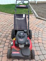 Full front view showing red deck, black Honda engine cover, grass catcher and handle
