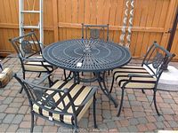 Full view of round table and four chairs with cushions on patio