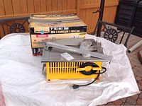 Workforce 7-inch tile wet saw on white sheet with box behind it showing product label and image.