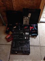 Overview photo showing Craftsman 14.4V cordless drill, Bosch 18V compact drill in their respective cases, and open accessory case containing numerous drill and screwdriver bits.