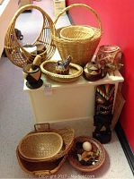 Assortment of woven baskets in various shapes and sizes along with African-style decorative items including carved masks, bowls, and animal figurines.