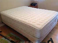 Full view of mattress atop box spring on metal frame in bedroom